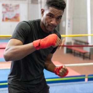 Young male boxer training on boxing ring